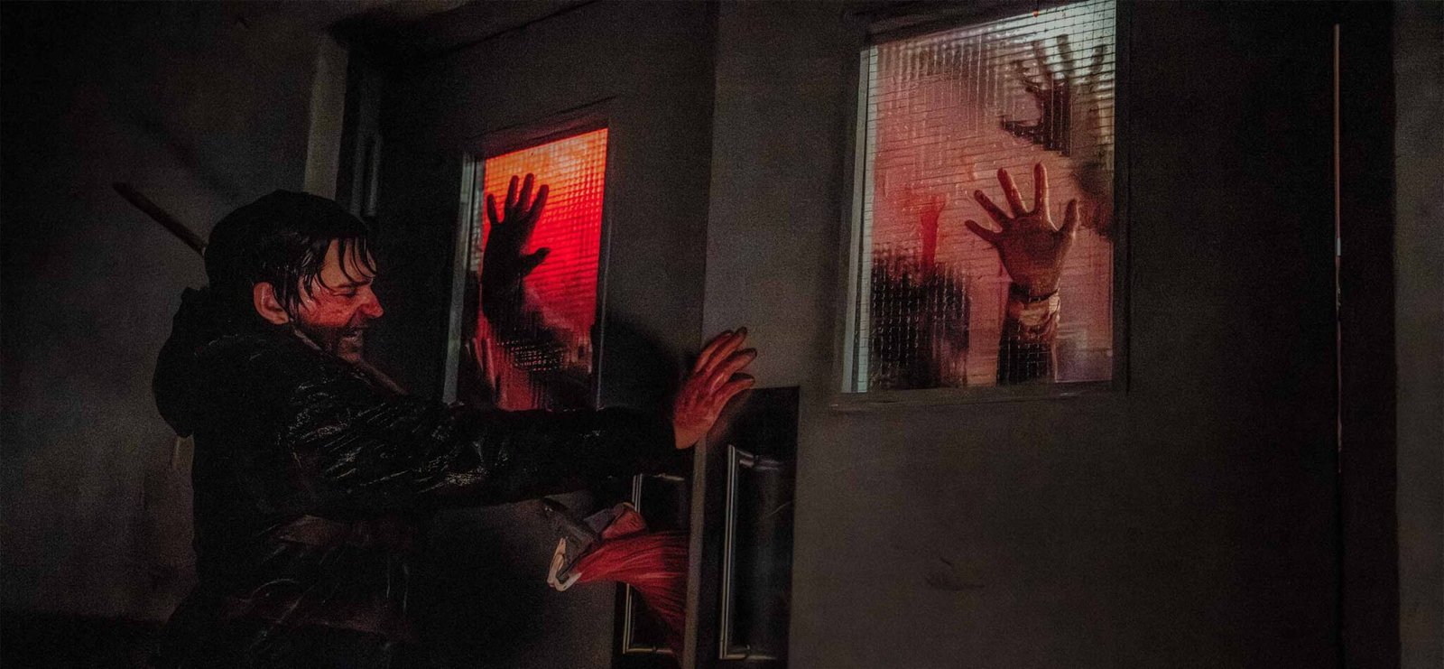 Austin Abrams en Resident Evil 2026 erncerrado manos zombies en cristal