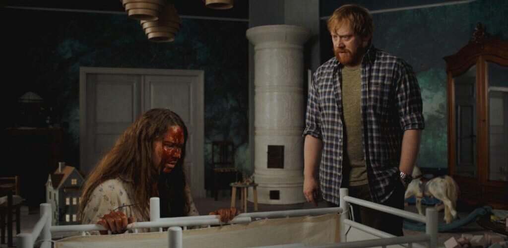 nightborn Seidi Haarla ensangrentada y Rupert Grint mirando una cuna