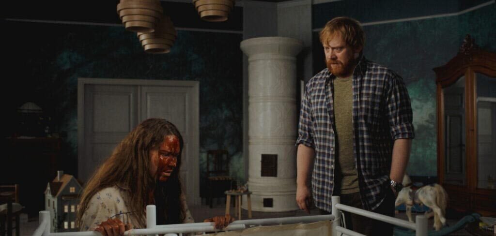 nightborn Seidi Haarla ensangrentada y Rupert Grint mirando una cuna
